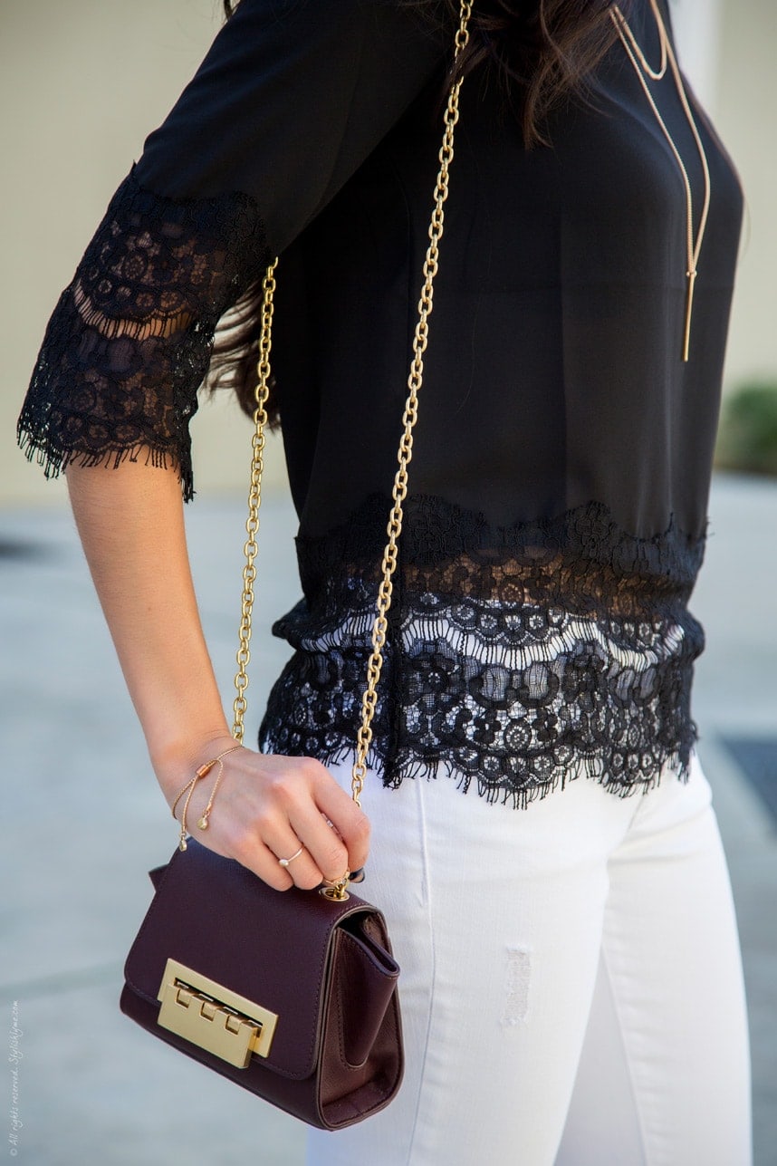 Pairing a black lace blouse with white jeans create a chic dressed up outfit for everyday